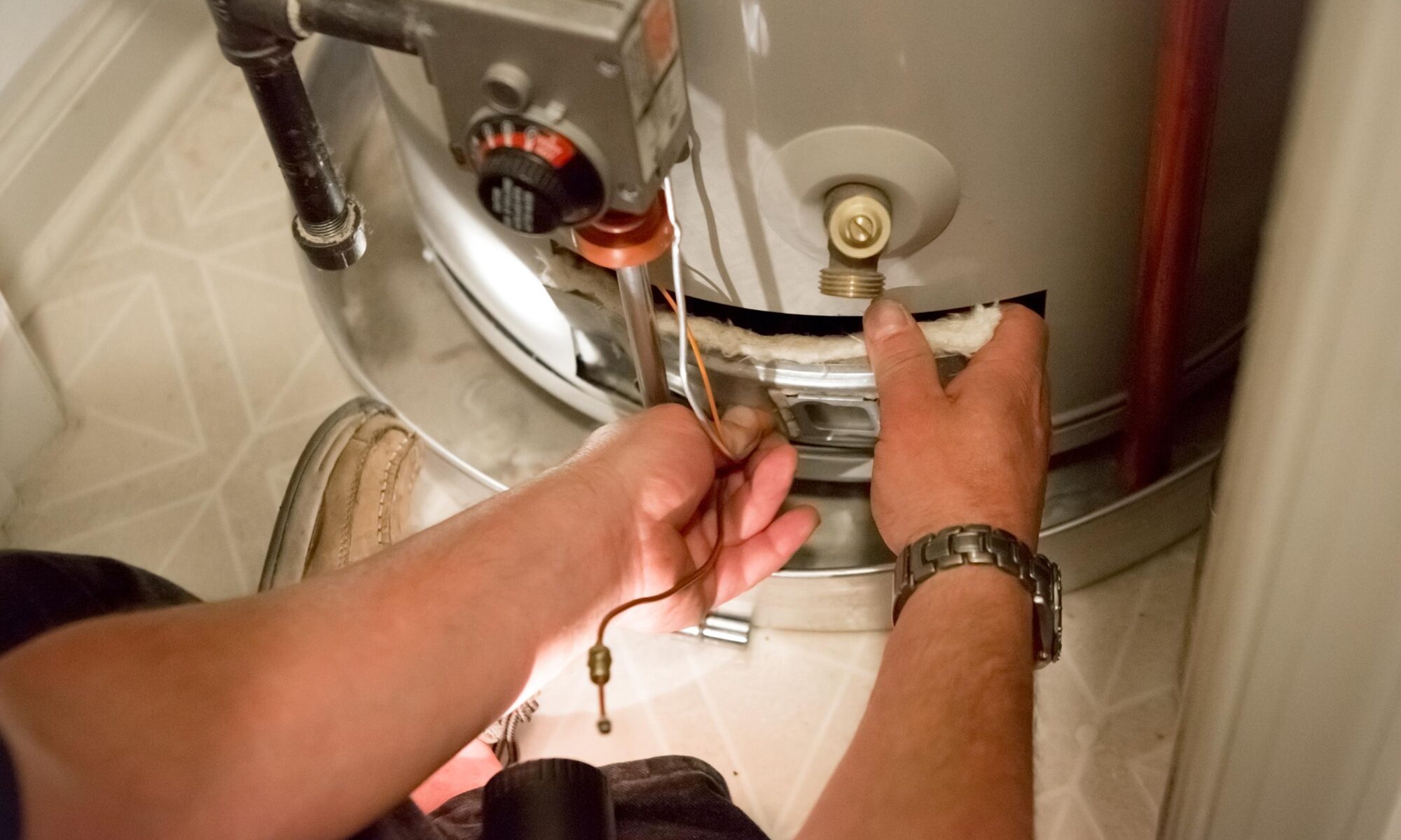 Technician repairing the gas control valve on a residential water heater